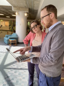 Eric and a librarian look at a laptop